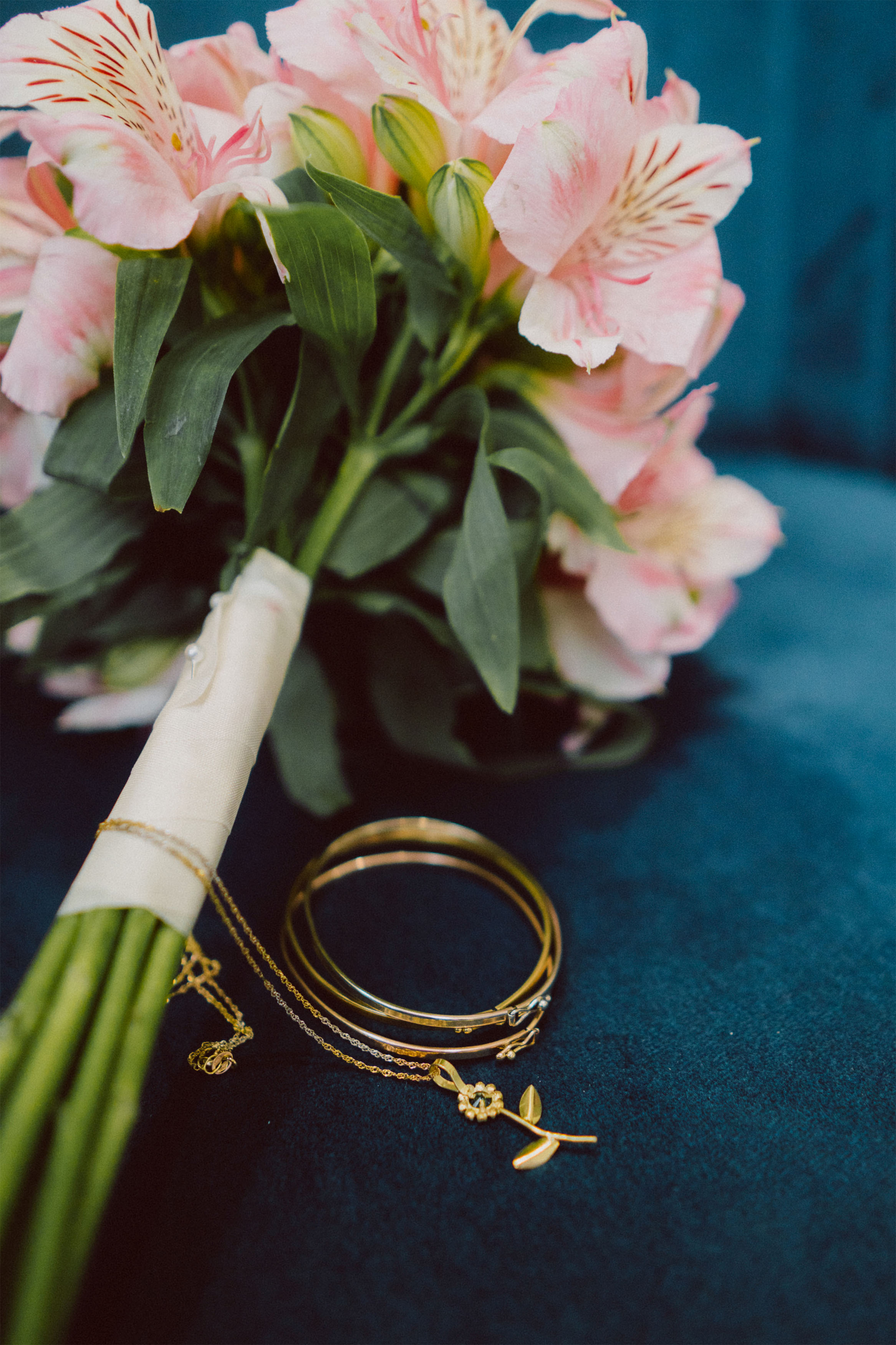 Buquê de noiva com alianças de casamento em destaque